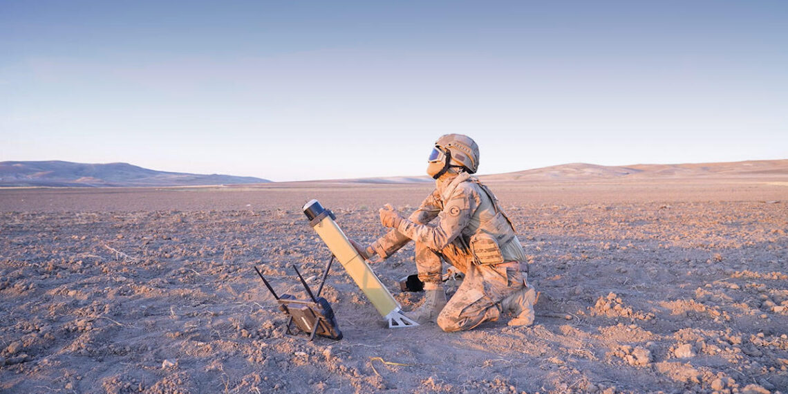 Sahada görev başındaki bir askerin STM Milli Vurucu İHA ALPAGU'yu fırlatmaya hazırlandığı operasyonel bir an.