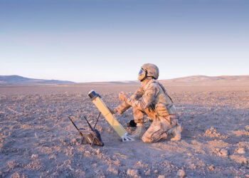 Sahada görev başındaki bir askerin STM Milli Vurucu İHA ALPAGU'yu fırlatmaya hazırlandığı operasyonel bir an.