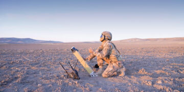 Sahada görev başındaki bir askerin STM Milli Vurucu İHA ALPAGU'yu fırlatmaya hazırlandığı operasyonel bir an.