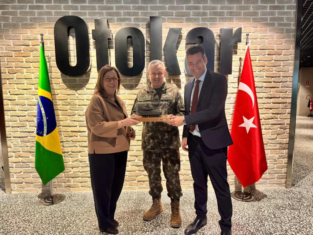 Brezilya ve Türkiye bayrakları önünde Otokar yetkilileri ve Brezilya Kara Kuvvetleri Komutanı hediye takdimi sırasında.