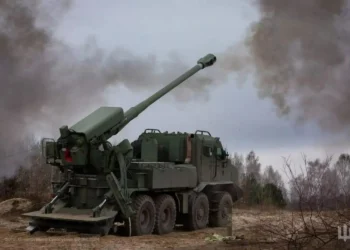 Modern self-propelled howitzer firing in an open field, representing firepower in the war of attrition