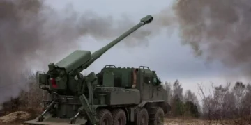 Modern self-propelled howitzer firing in an open field, representing firepower in the war of attrition