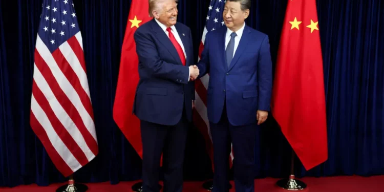 Donald Trump and Xi Jinping shaking hands in front of US and Chinese flags, symbolizing the shift in the 2026 National Defense Strategy
