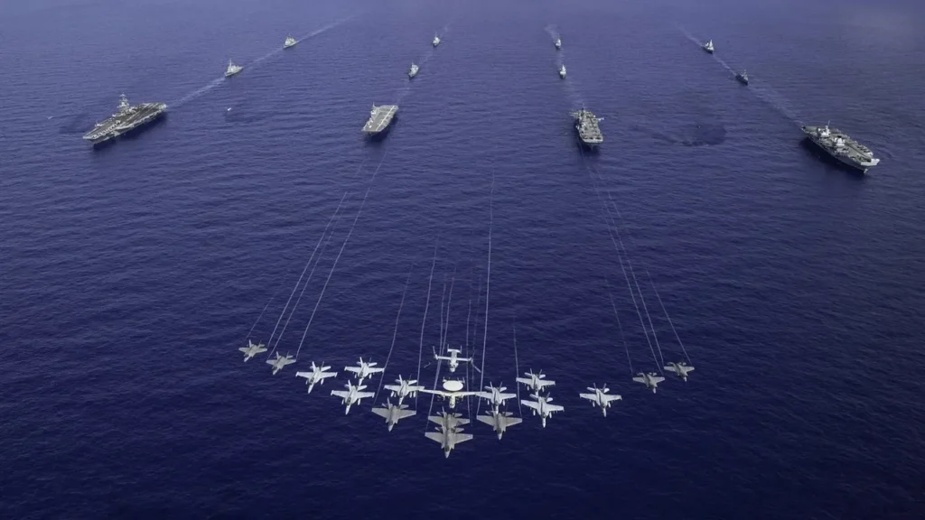 Küresel savunma sanayiinde Nadir Toprak Elementleri (NTE) krizinden etkilenen askeri deniz gücü dengeleri ve çok uluslu bir donanma filosu.