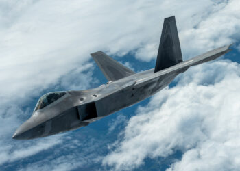 F-22 Raptor stealth fighter jet flying through clouds, representing Mobix Labs' expanded role in the defense program.