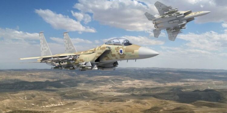 Two F-15IA fighter jets with Israeli Air Force markings flying over a desert landscape.