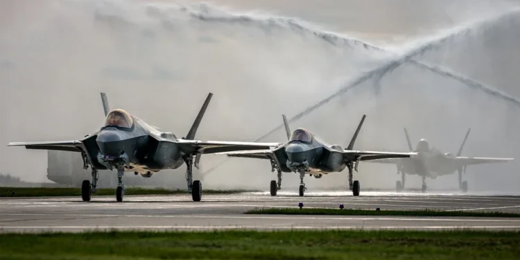 Polish Air Force F-35 Husarz fighter jets taxiing under a water salute during the entry into service ceremony at the 32nd Tactical Air Base in Lask, Poland.