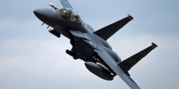 US Air Force KC-135 Stratotanker refueling an F-15E Strike Eagle in mid-air`