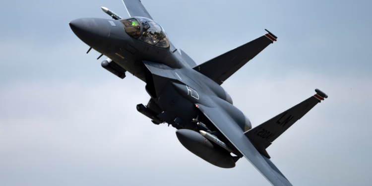 US Air Force KC-135 Stratotanker refueling an F-15E Strike Eagle in mid-air`